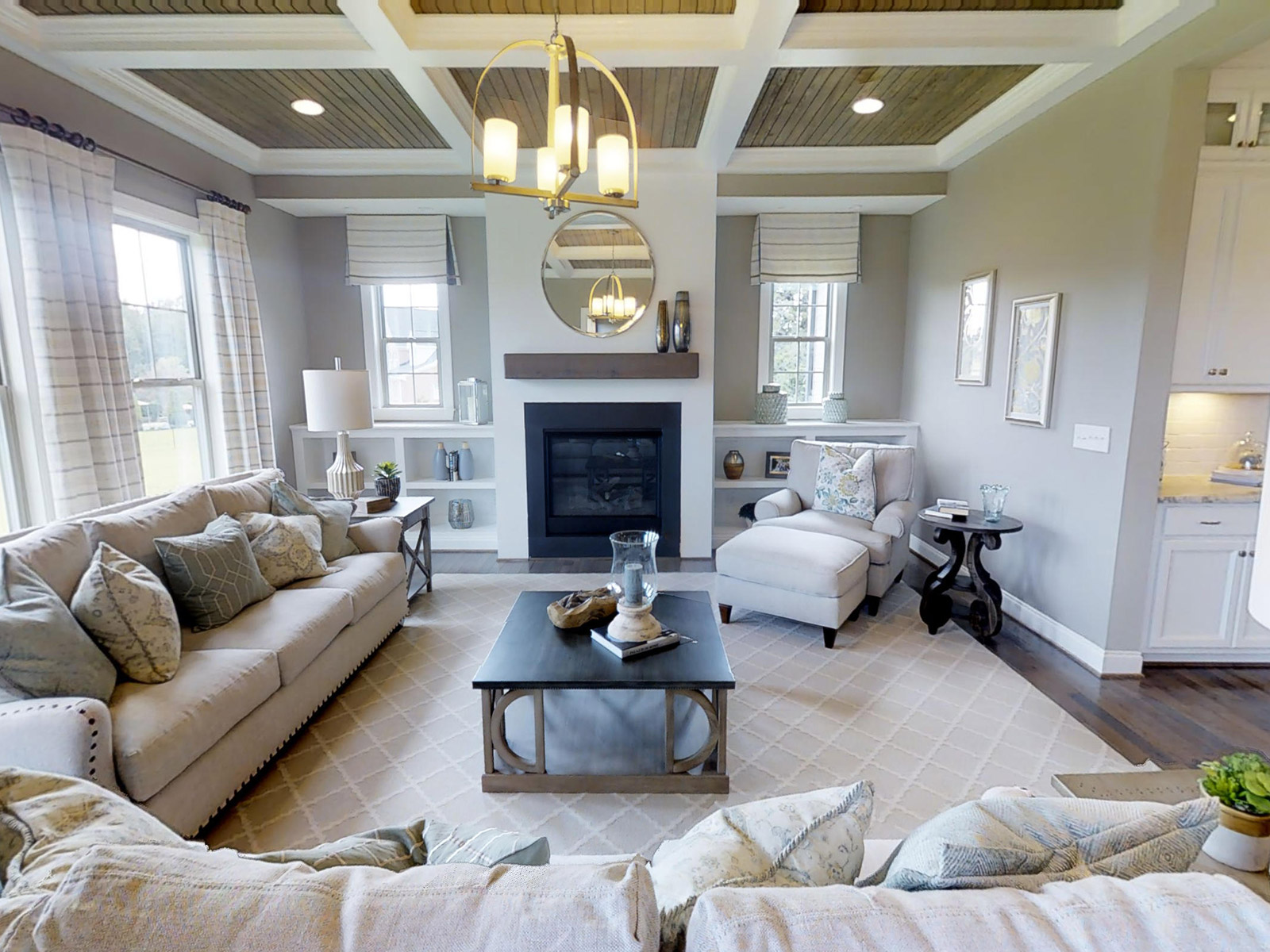 Family room with built-in bookshelves and coffered wood ceiling in the Crawford plan at Banks Pointe.