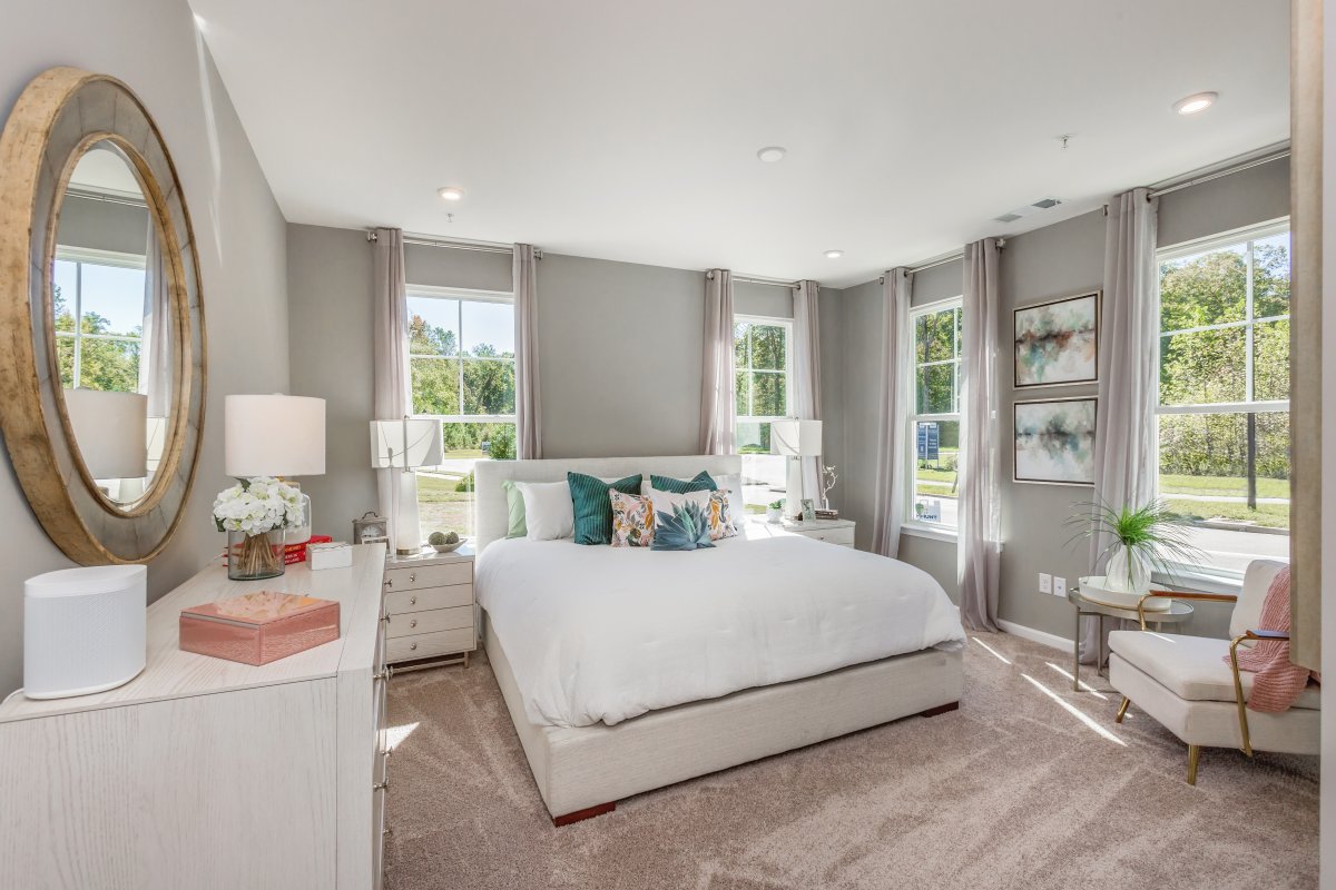 Primary suite in the Lincoln floor plan by HHHunt Homes at The Pointe at Twin Hickory, featuring a spacious layout with neutral décor, large windows, and elegant furnishings.