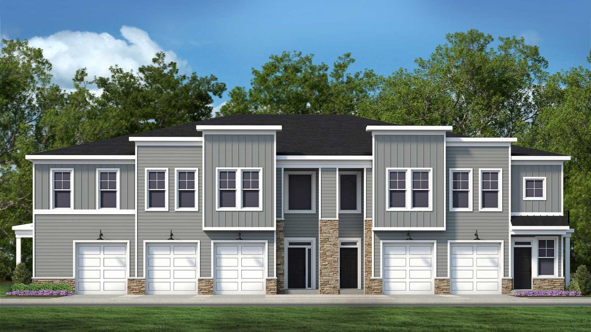 Wescott Condos by HHHunt Homes streetscape view featuring modern two-story condominium units with gray siding, white trim, stone accents, and individual garages, set against a backdrop of green trees and blue sky.