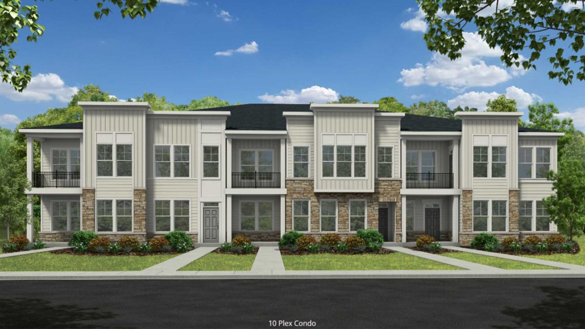 Wescott Condos Bristol 2 streetscape by HHHunt Homes, showcasing a modern 10-plex condo building with stone and siding exterior, covered entryways, and second-floor balconies framed by trees and landscaped paths.
