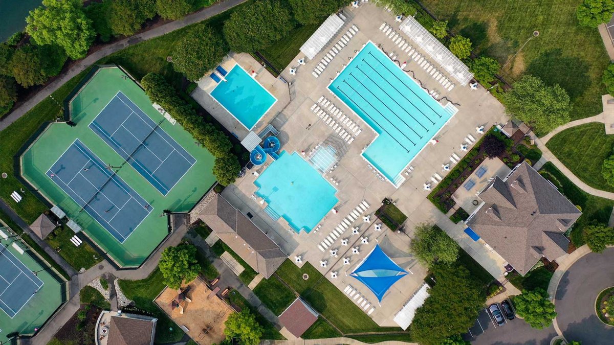 Aerial view of community amenities at The Pointe at Twin Hickory by HHHunt, featuring multiple pools, water slides, tennis courts, and clubhouse facilities.