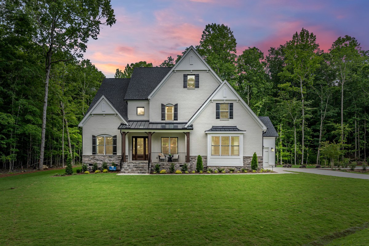 Exterior of the Crawford floor plan (European elevation) by HHHunt Homes at The Summit at Morgan Ridge, showing an elegant European manor style with white brick and stone accents.
