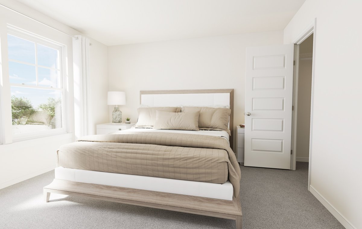 Primary suite in the Haywood floor plan by HHHunt Homes at McQuillan Pines with gray carpet, beige and white bedding, and natural light.