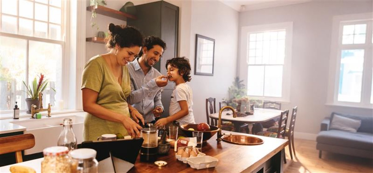 Young family in the kitchen making dinner.