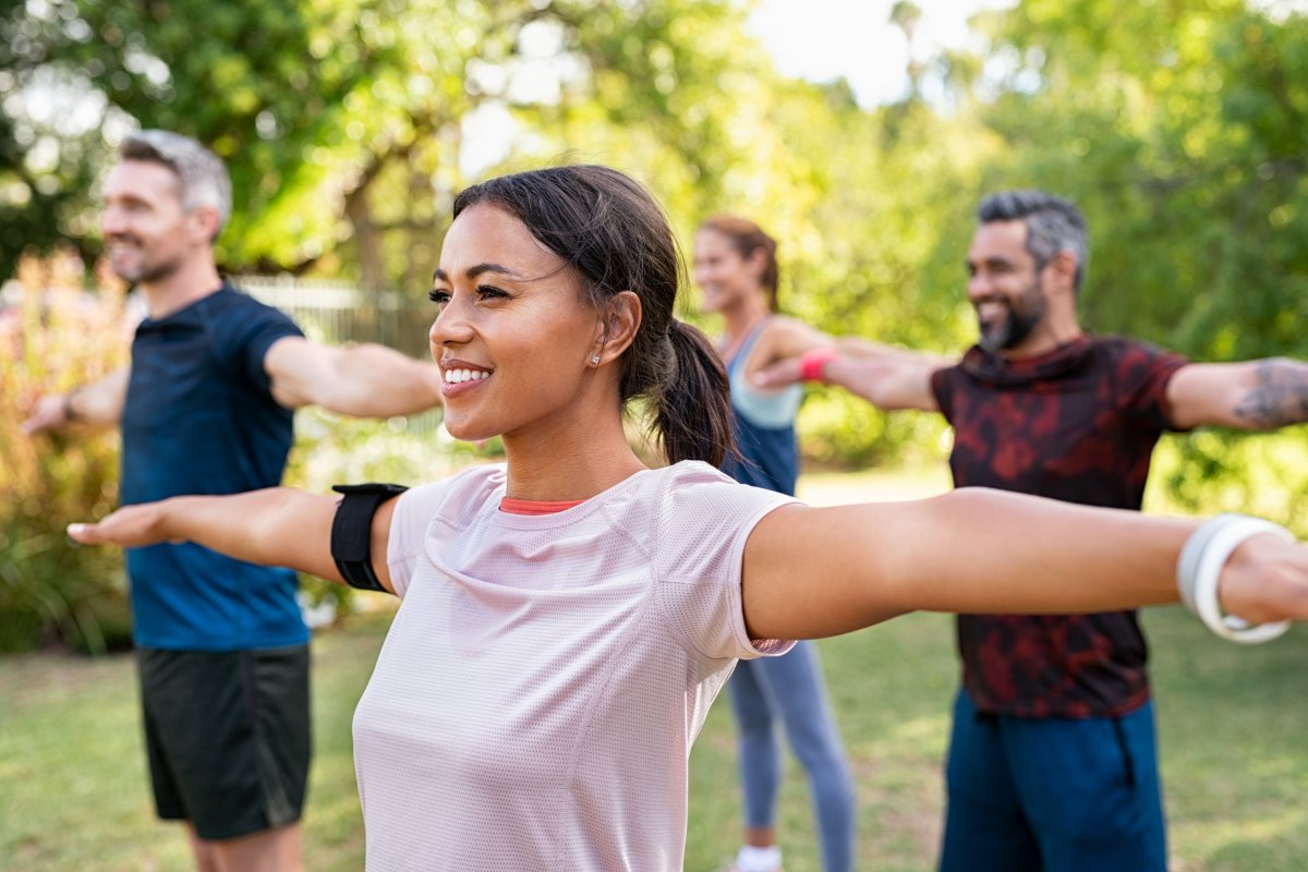 Four people doing yoga in the park