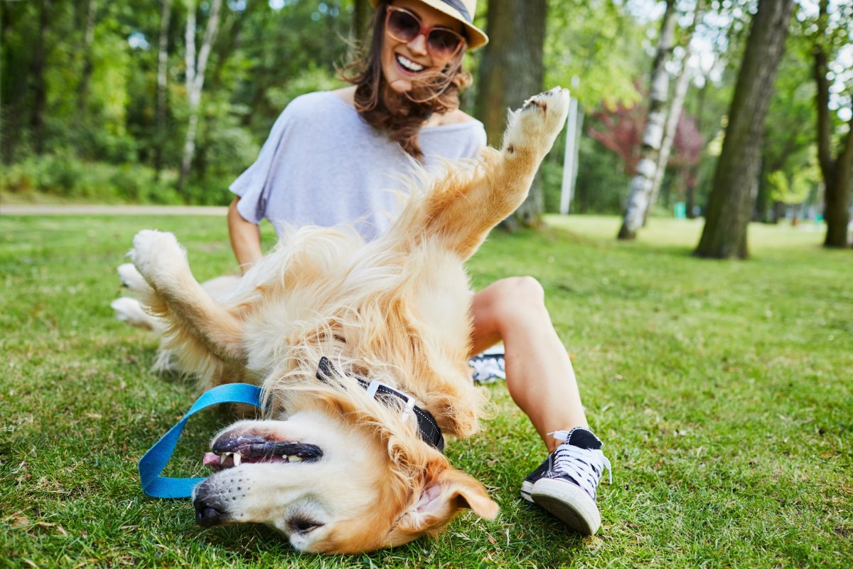 Woman outside playing with her dog in the grass