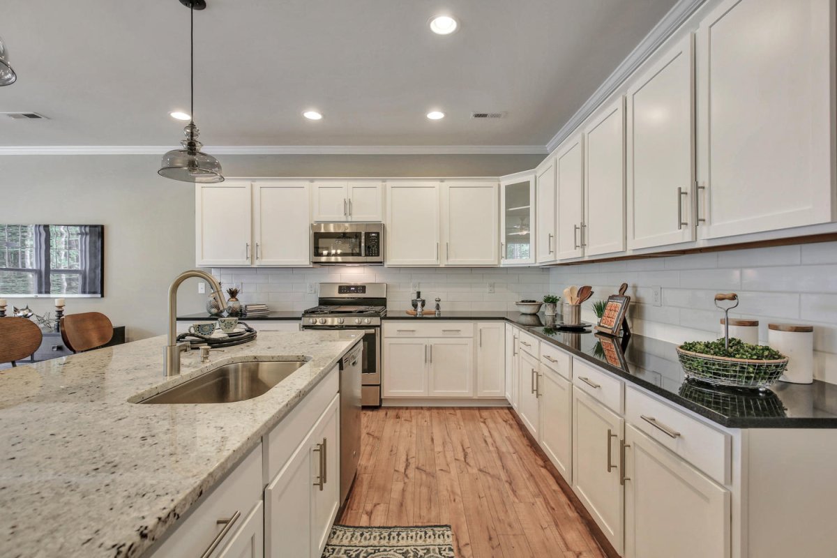 Kitchen in a Granite Ridge townhome by HHHunt Homes with wood cabinetry, quartz island, and pendant lighting.