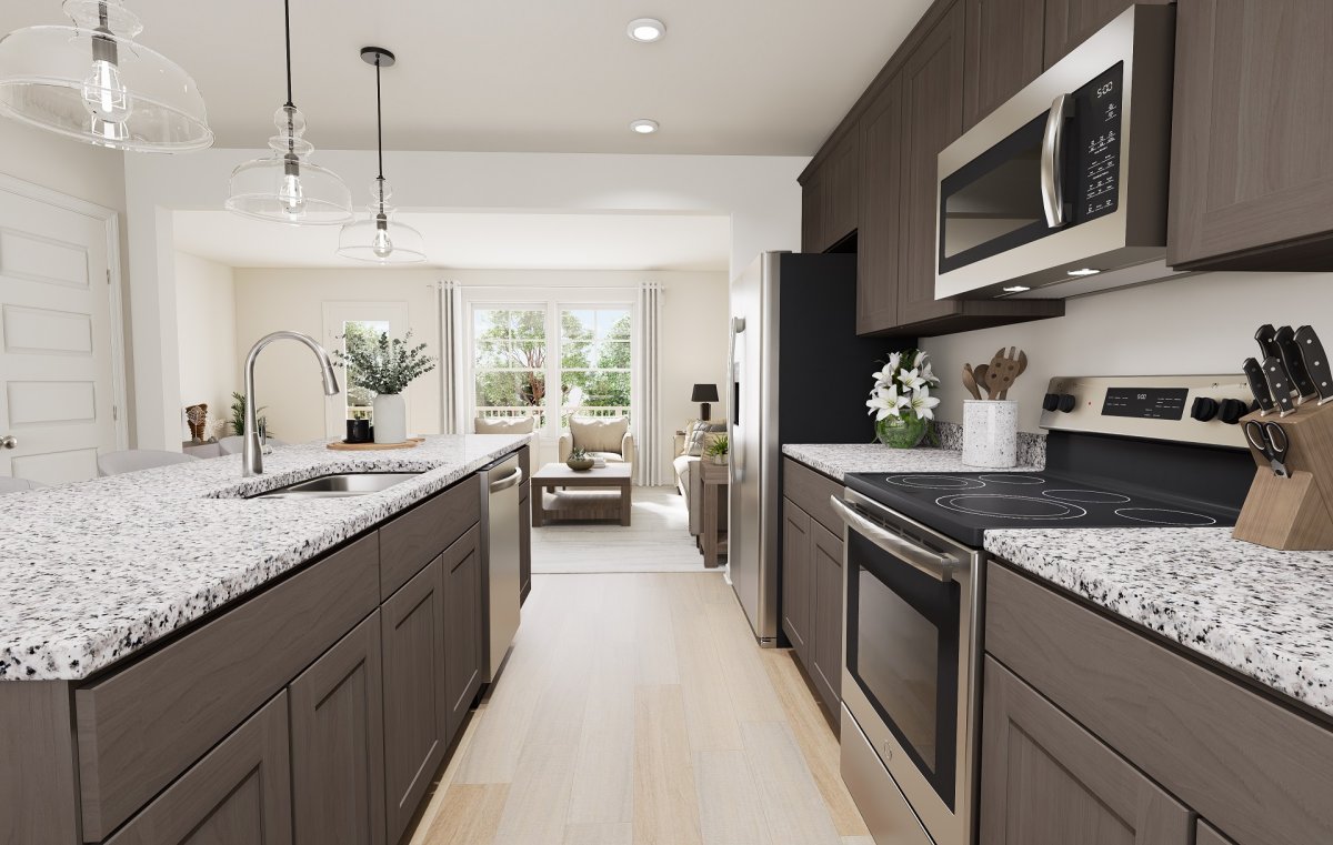 Kitchen in the Haywood floor plan at Edgebrook by HHHunt Homes, featuring an open kitchen with island, granite countertops, stainless steel appliances, pendant lighting, and sightlines to the living area.